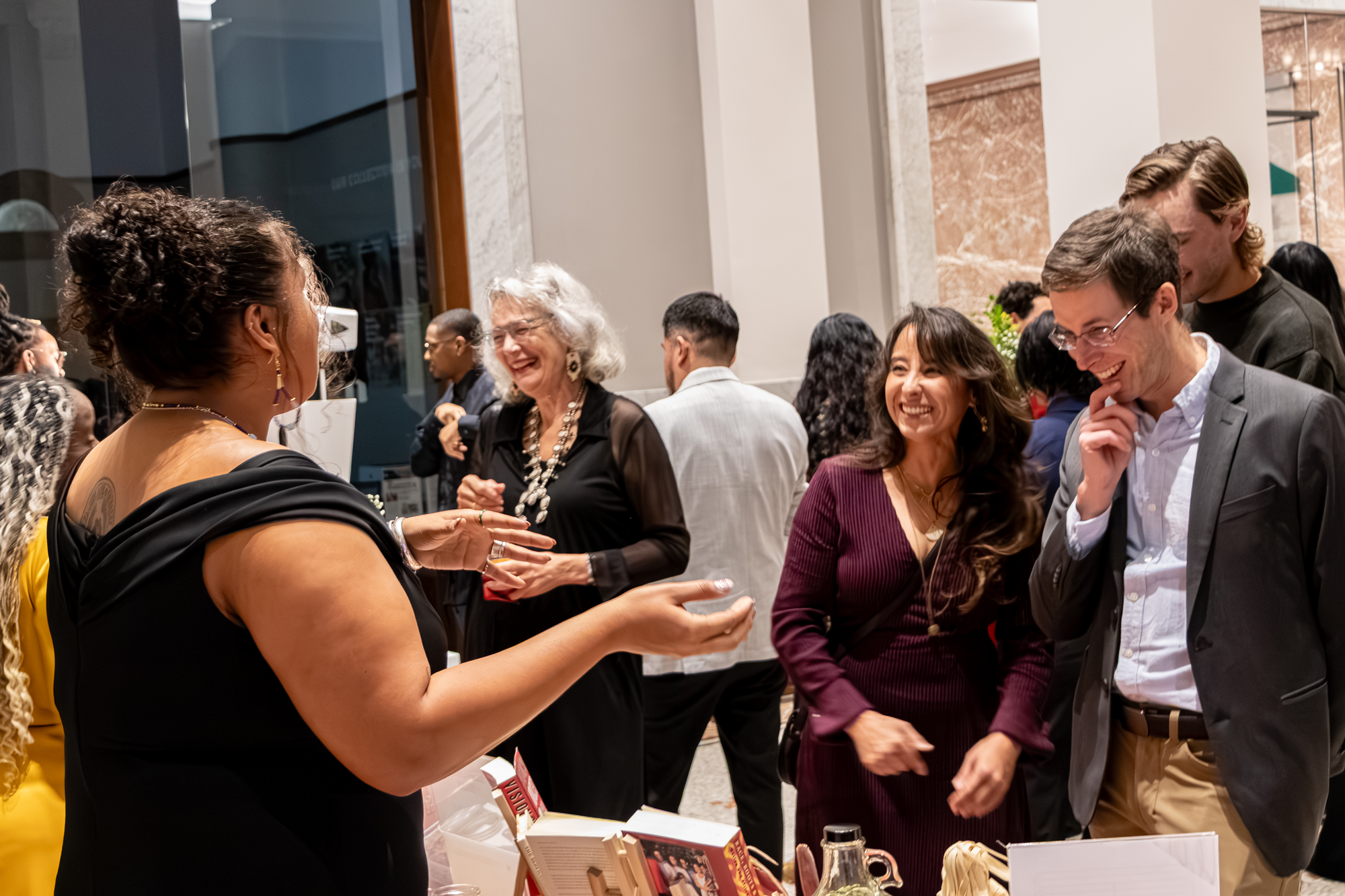 Guests laughing together while visiting an art pop-up during the American Indian Center gala at the Newberry Library.